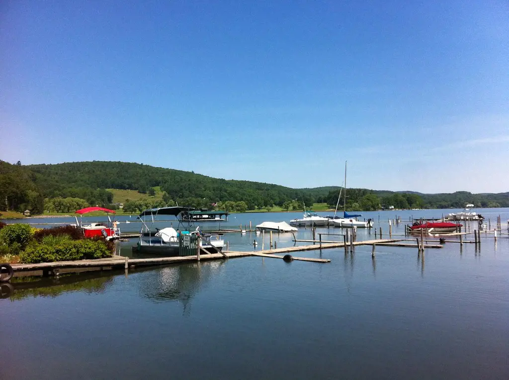 Boats on standby at the green banks of the Otsego Lake 